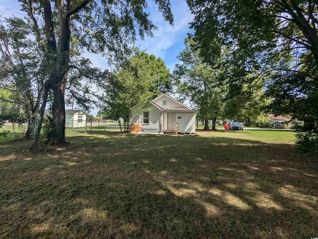 view of yard featuring entry steps and fence