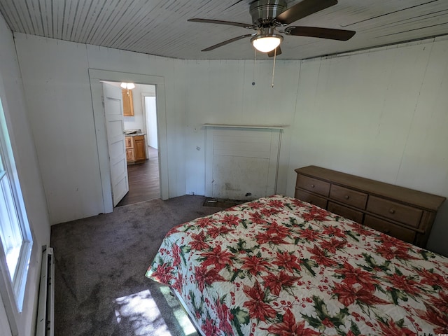 bedroom with a baseboard heating unit, dark colored carpet, and ceiling fan