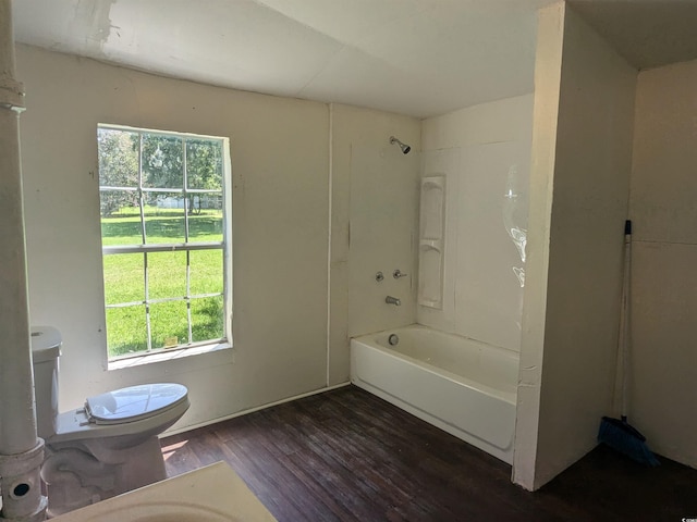 full bath with tub / shower combination, wood finished floors, and toilet