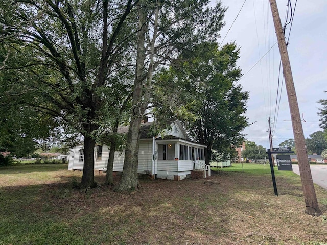 view of side of home featuring crawl space and a lawn