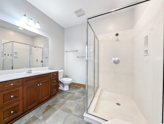 bathroom with vanity, toilet, and a shower with door