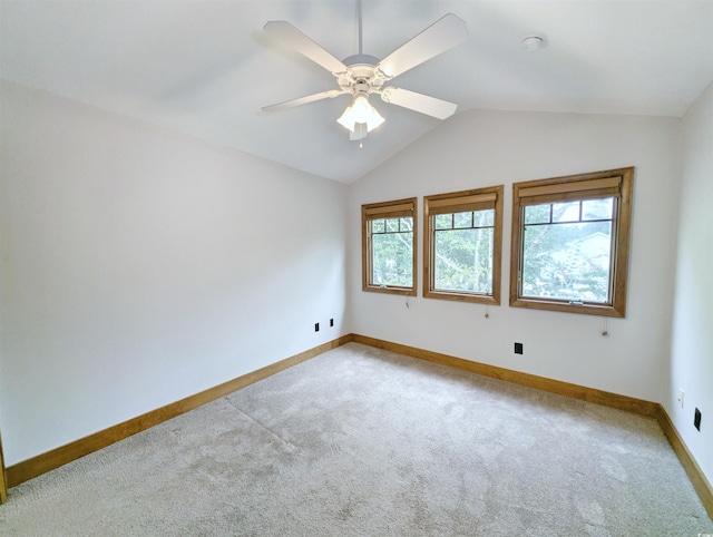 carpeted empty room featuring vaulted ceiling and ceiling fan