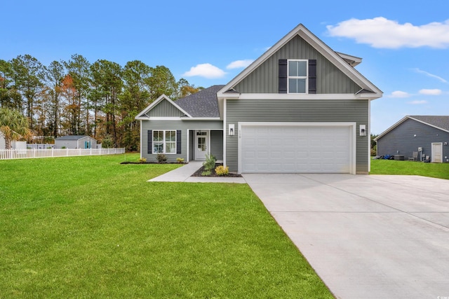 craftsman-style home featuring a garage, fence, driveway, a front lawn, and board and batten siding