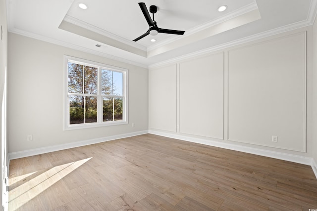 unfurnished bedroom featuring crown molding, visible vents, a raised ceiling, and wood finished floors