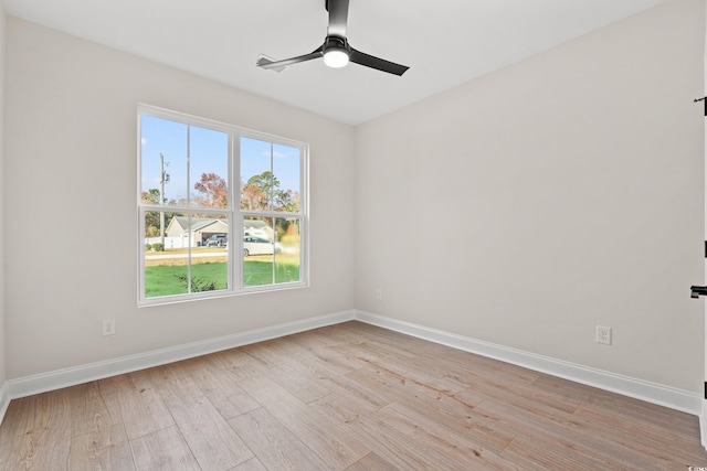 spare room featuring light wood-style floors, ceiling fan, and baseboards