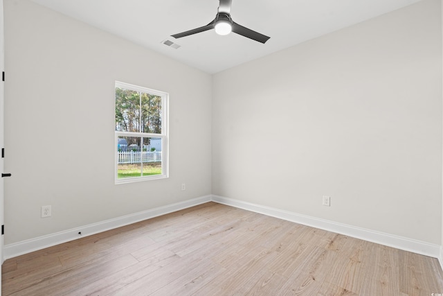 empty room featuring light wood-style floors, visible vents, baseboards, and a ceiling fan