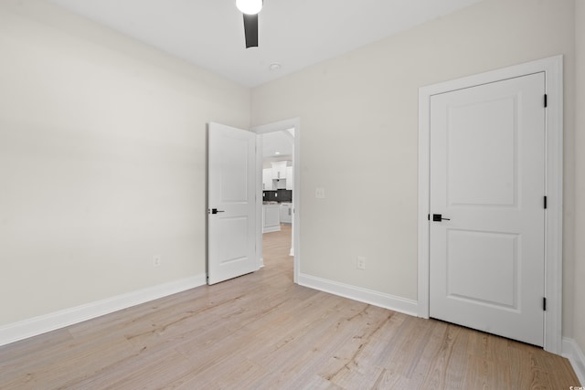 unfurnished bedroom featuring light wood-style floors, ceiling fan, and baseboards