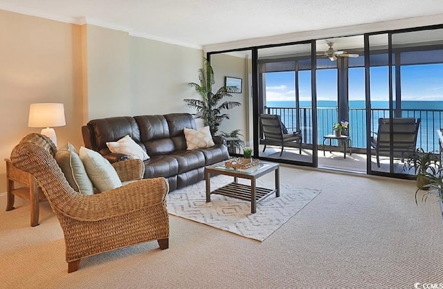 carpeted living room with ceiling fan, expansive windows, a water view, and crown molding