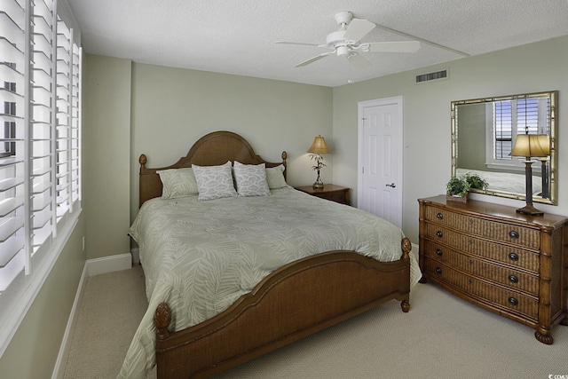 carpeted bedroom featuring a textured ceiling and ceiling fan