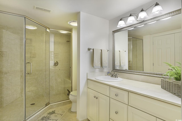 bathroom featuring tile patterned floors, a shower with door, vanity, and toilet