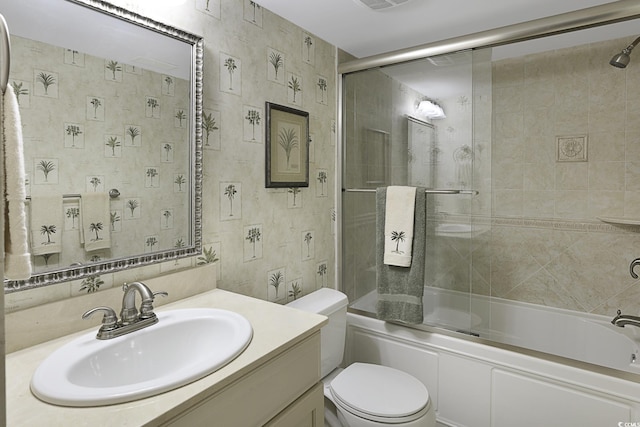 full bathroom featuring vanity, bath / shower combo with glass door, and toilet