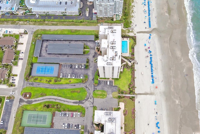 birds eye view of property with a water view and a beach view