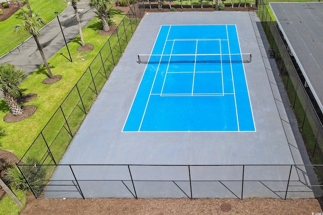 view of tennis court featuring a yard