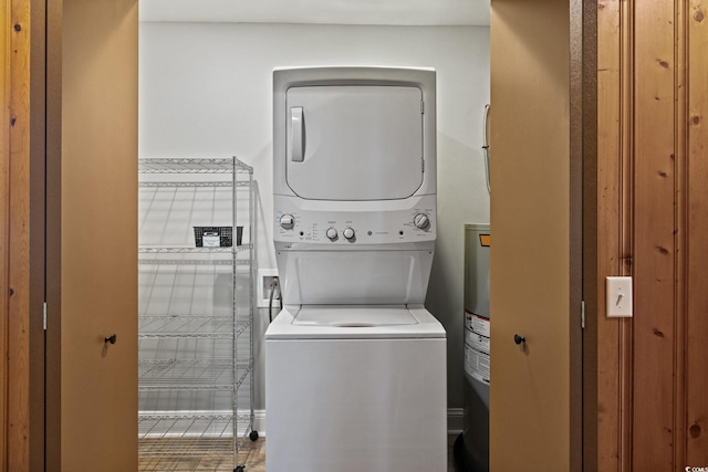 clothes washing area featuring stacked washing maching and dryer