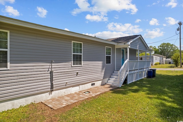 view of side of home with a yard