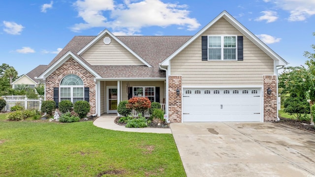 view of front of property featuring driveway, brick siding, an attached garage, fence, and a front yard