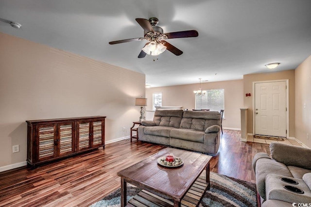 living room featuring wood-type flooring and ceiling fan with notable chandelier