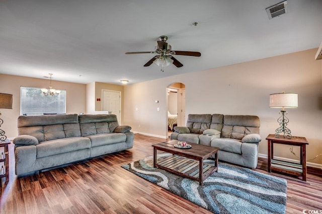 living room with hardwood / wood-style flooring and ceiling fan with notable chandelier