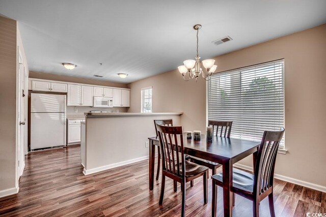 dining area featuring a notable chandelier and hardwood / wood-style floors