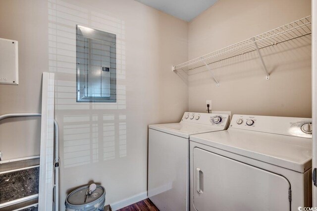 washroom featuring electric panel, independent washer and dryer, and dark hardwood / wood-style floors