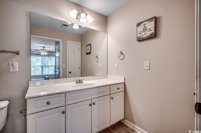 bathroom with tile patterned flooring, toilet, vanity, and ceiling fan