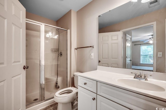 bathroom featuring walk in shower, toilet, vanity, ceiling fan, and tile patterned floors