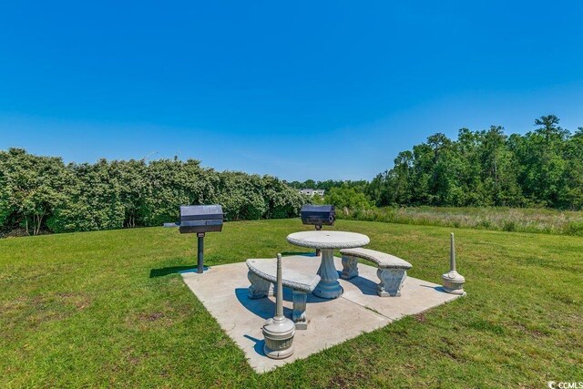 view of home's community featuring a lawn and a patio area