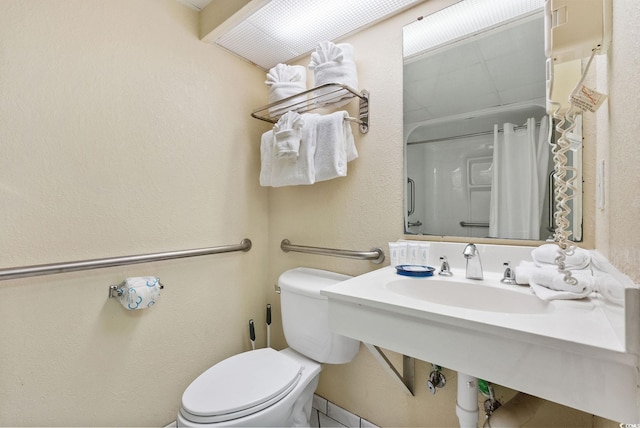 bathroom with tile patterned flooring, toilet, and sink