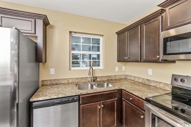 kitchen featuring sink, dark brown cabinets, light stone counters, and stainless steel appliances