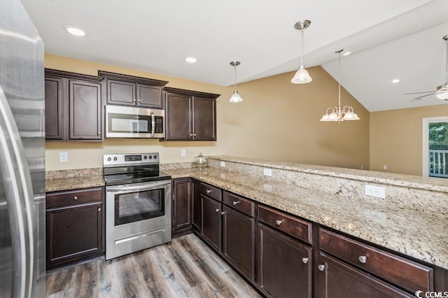 kitchen featuring hanging light fixtures, ceiling fan with notable chandelier, hardwood / wood-style floors, appliances with stainless steel finishes, and light stone countertops