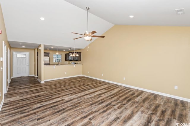 unfurnished living room with ceiling fan with notable chandelier, high vaulted ceiling, and wood-type flooring