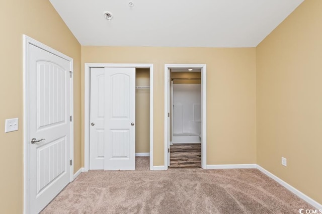 unfurnished bedroom featuring carpet flooring and vaulted ceiling