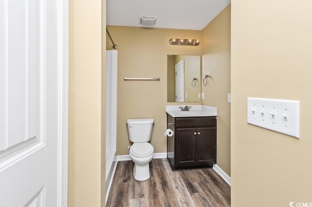 bathroom featuring toilet, hardwood / wood-style floors, vanity, and walk in shower