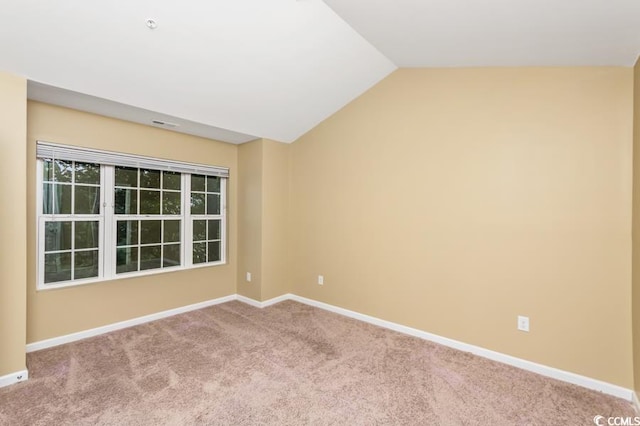 carpeted empty room with lofted ceiling