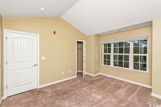 unfurnished room featuring carpet flooring and vaulted ceiling