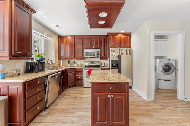 kitchen with sink, a center island, light hardwood / wood-style floors, and appliances with stainless steel finishes