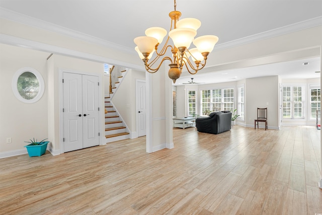 interior space featuring crown molding, ceiling fan with notable chandelier, and light wood-type flooring