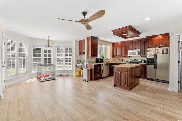 kitchen featuring plenty of natural light, a kitchen island, stainless steel appliances, and light wood-type flooring