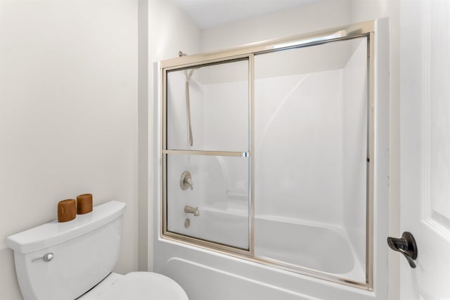 bathroom with shower / bath combination with glass door and toilet