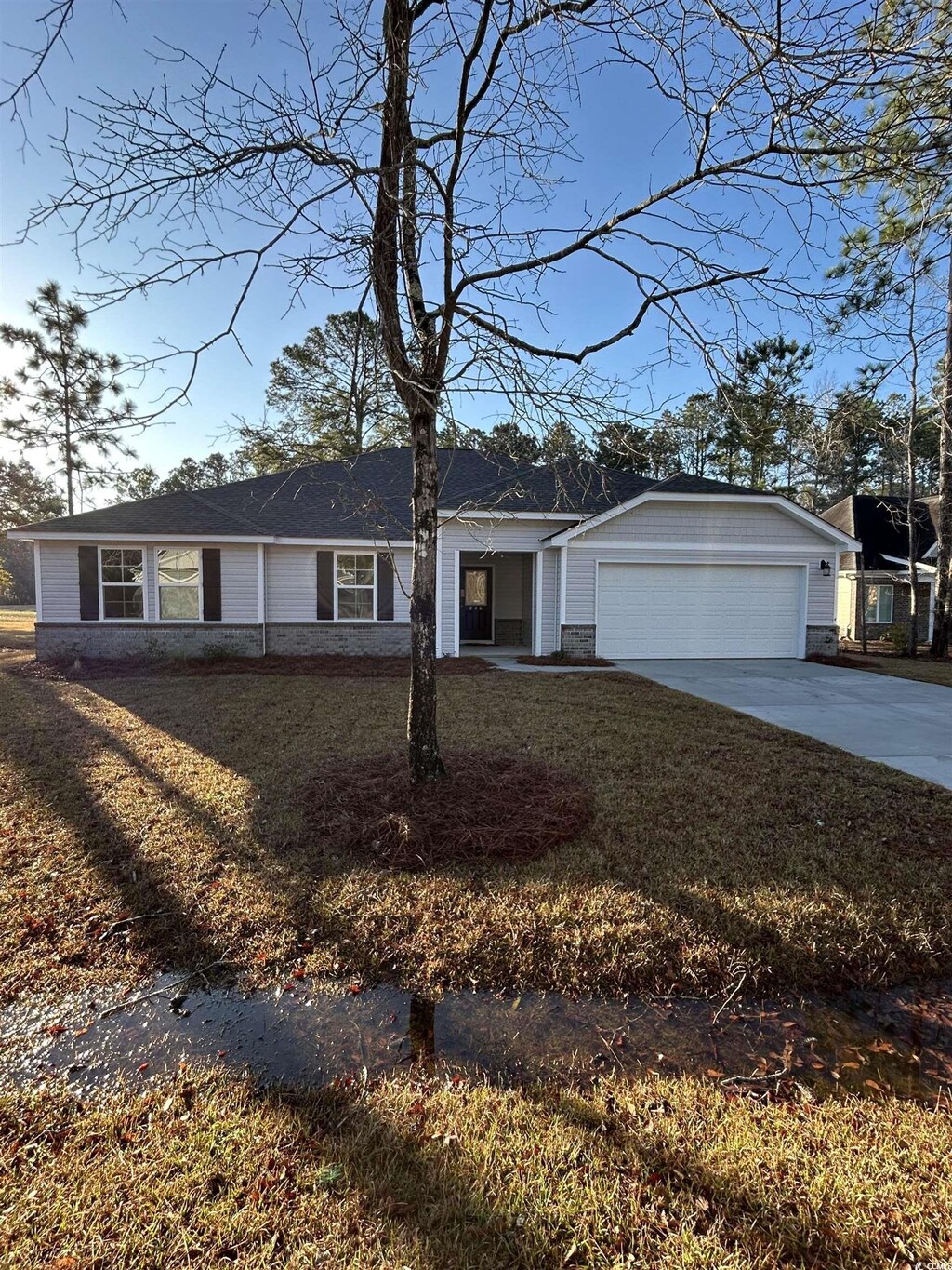 ranch-style home with a garage and a yard