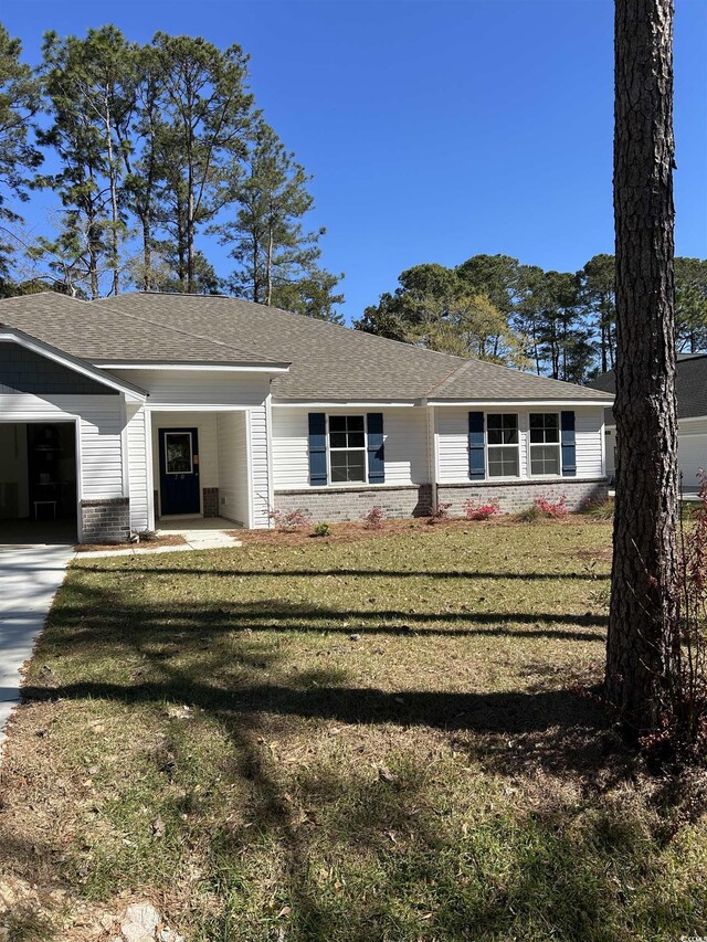 ranch-style home featuring a garage and a lawn