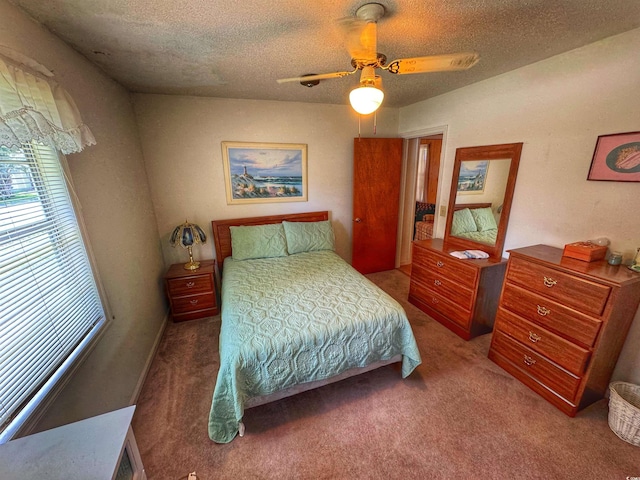 carpeted bedroom featuring ceiling fan and a textured ceiling