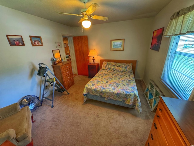 bedroom with a ceiling fan and light colored carpet