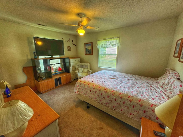 carpeted bedroom with ceiling fan, visible vents, and a textured ceiling