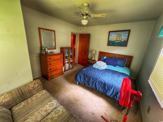 bedroom with a ceiling fan, carpet, and a textured ceiling