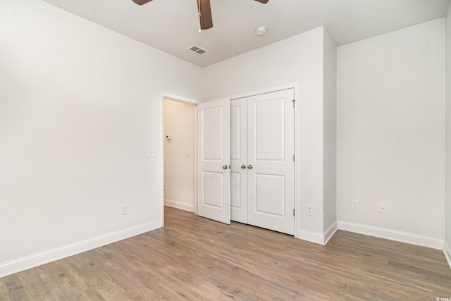 unfurnished bedroom featuring wood-type flooring, a closet, and ceiling fan