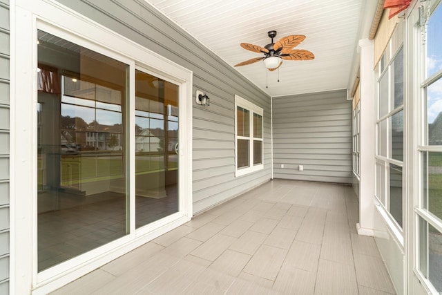 unfurnished sunroom featuring wood ceiling and ceiling fan