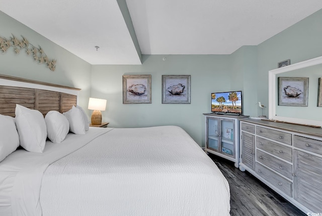 bedroom featuring indoor bar and dark wood-type flooring