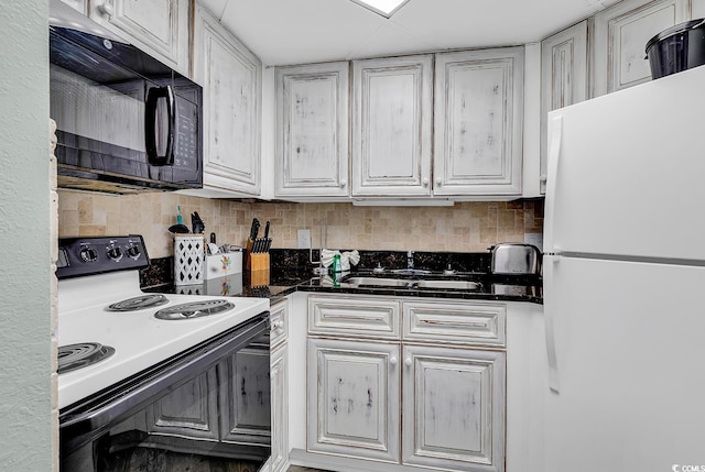 1501 S Ocean Blvd Unit 1150, Myrtle Beach, SC 29577 - kitchen featuring white cabinets, electric range oven, freestanding refrigerator, black microwave, and backsplash