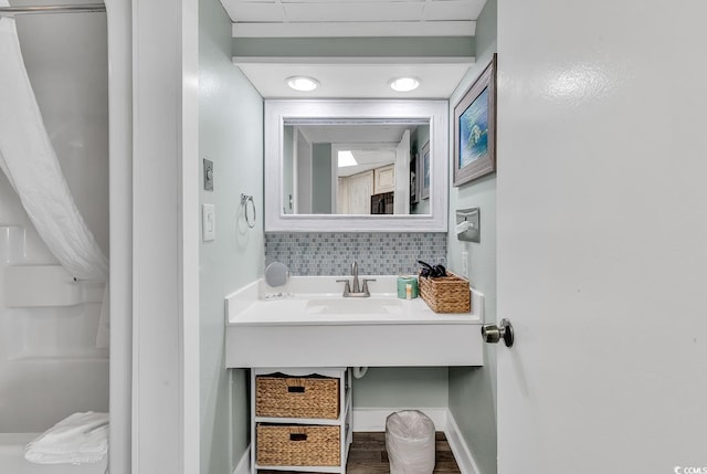 kitchen featuring hardwood / wood-style flooring, sink, decorative backsplash, white appliances, and dark stone countertops